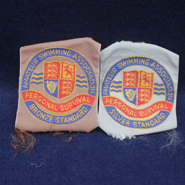 Two embroidered patches from the Amateur Swimming Association on a dark blue background.