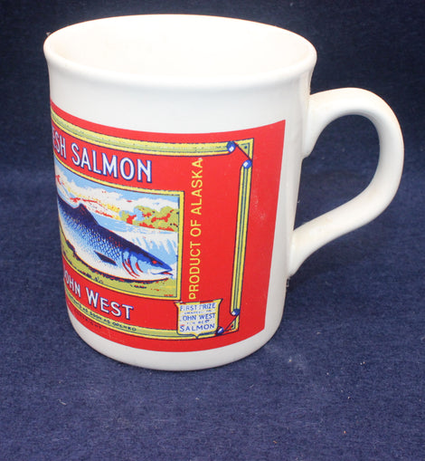 White mug with a red John West salmon label on a blue background