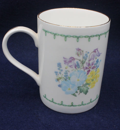 White mug with floral design on a dark blue background