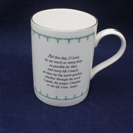 White mug with green rim and text on a dark blue background