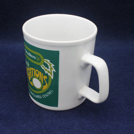 White mug with a green and yellow logo on a dark blue background