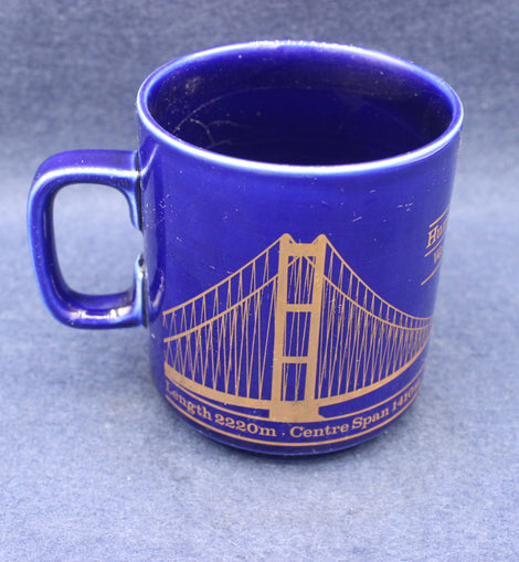 Blue mug with a gold bridge design on a blue background