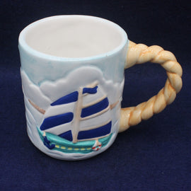 Ceramic mug with ship design and rope handle on a dark background