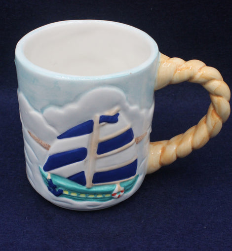 Ceramic mug with ship design and rope handle on a dark background