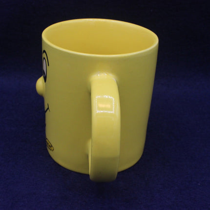 Yellow mug with a handle on a dark blue background
