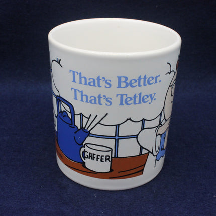 White mug with cartoon design and 'That's Better, That's Tetley' text on a dark blue background