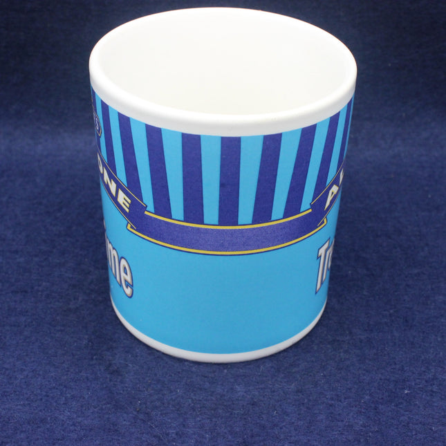 Blue and white mug with striped design on a blue background