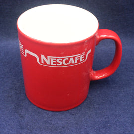 Red mug with Nescafe logo on a blue background