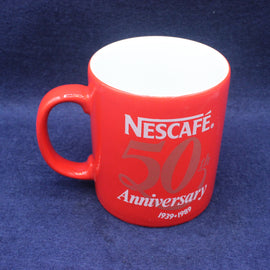 Red Nescafe mug celebrating 50th anniversary on a blue background
