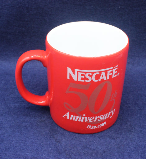Red Nescafe mug celebrating 50th anniversary on a blue background