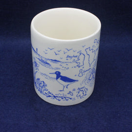White ceramic mug with blue bird illustrations on a dark blue background
