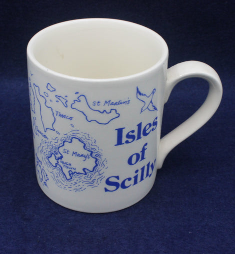White mug with blue 'Isles of Scilly' design on a dark blue background