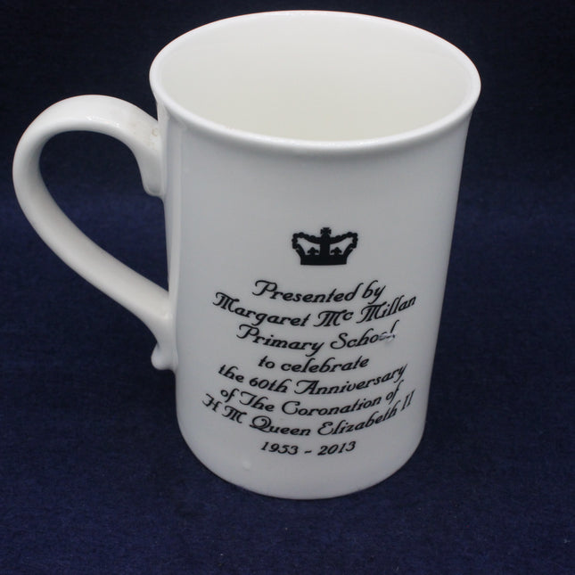 White mug with engraved text and a crown symbol on a dark blue background