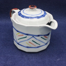 Ceramic tea pot with colorful patterns on a blue background