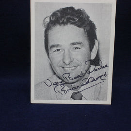 Black and white photo of a Brian Clough with autograph on a dark background