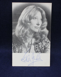 Black and white photo of Leslie Judd with a signature below on a dark background