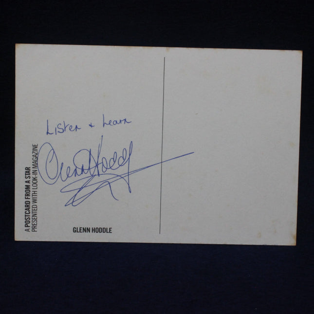 Autographed card with a signature on a dark background