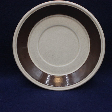Ceramic saucer with a textured surface on a dark background