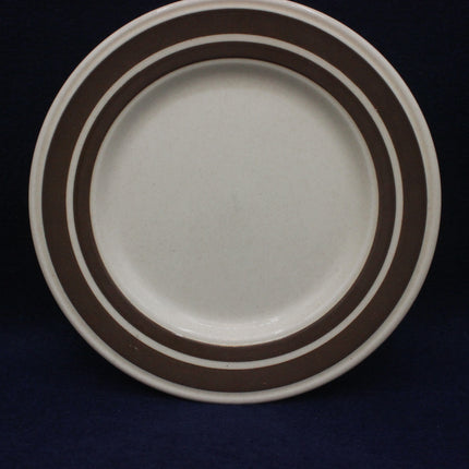 White plate with brown stripes on a black background