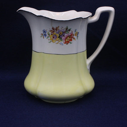 Ceramic pitcher with floral design on a dark blue background