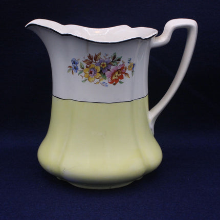 Vintage ceramic jug with floral design on a dark blue background
