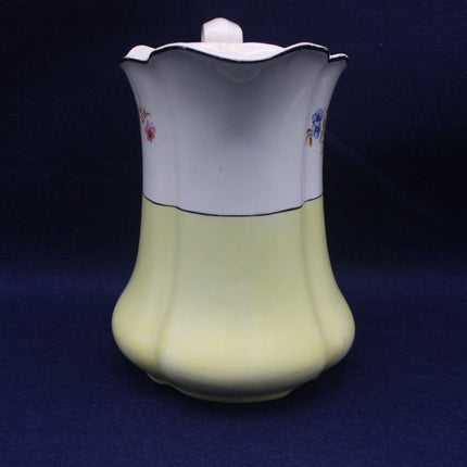 Ceramic jug with floral designs on a dark blue background