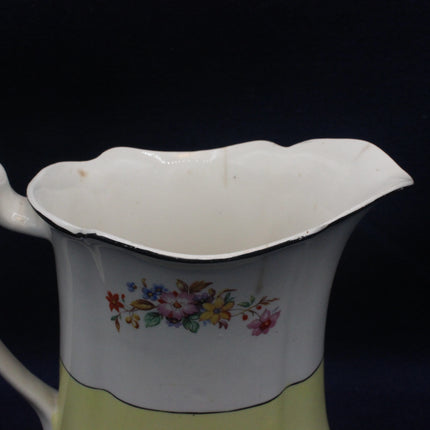 Vintage ceramic pitcher with floral design on a dark background