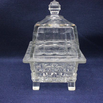 Clear glass dish with a lid on a dark blue background