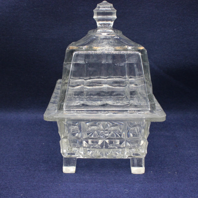 Clear glass dish with a lid on a dark blue background