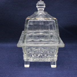 Clear glass dish with a lid on a dark blue background