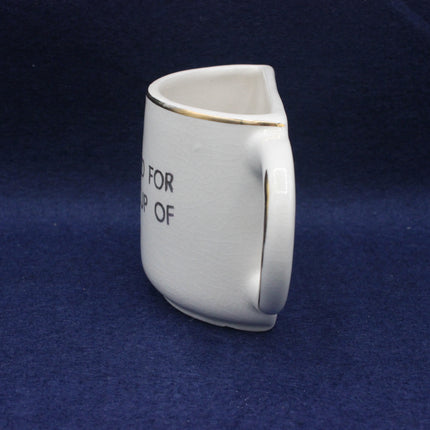 White ceramic mug with text on a blue background