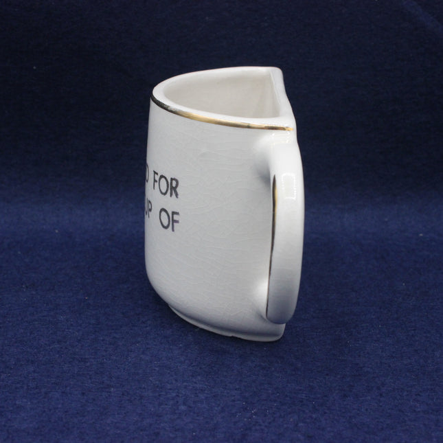 White ceramic mug with text on a blue background