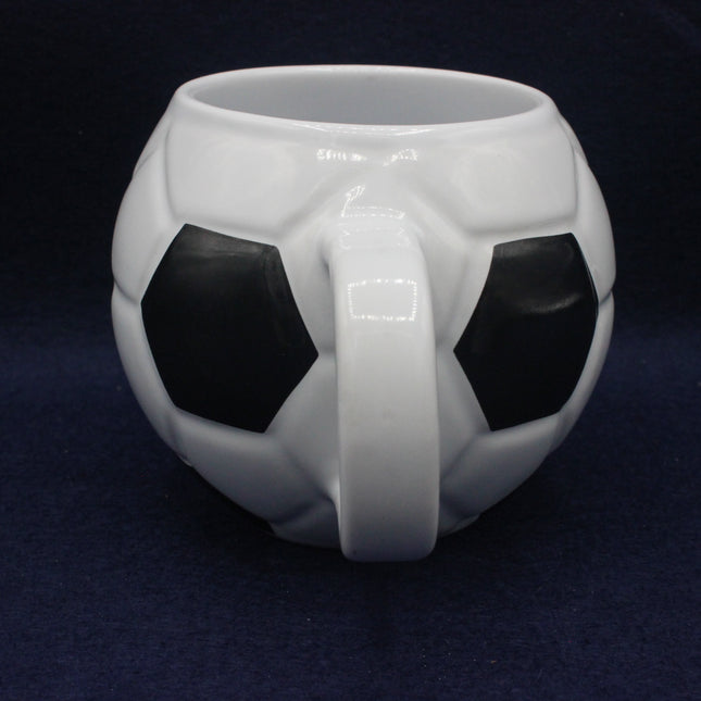 White mug designed like a soccer ball on a dark blue background