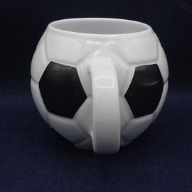 White mug designed like a soccer ball on a dark blue background