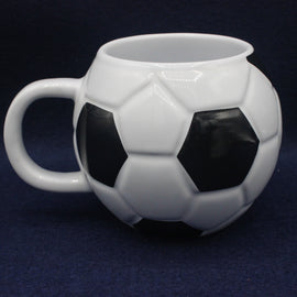 White ceramic mug shaped like a soccer ball on a dark background