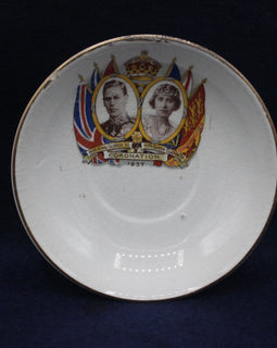 Decorative plate with royal portraits and British flags on a dark background