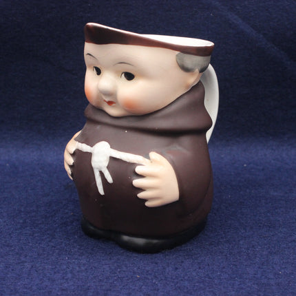 Ceramic figurine of a monk with a brown habit on a blue background