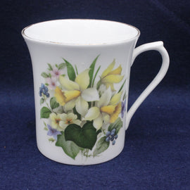 White mug with floral design on a dark blue background