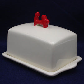 White butter dish with a red anchor on a dark blue background
