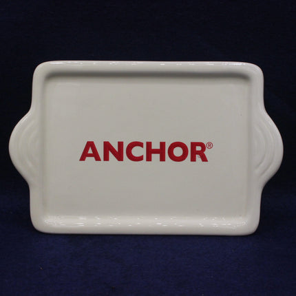 White butter  tray with 'Anchor' logo on a dark background
