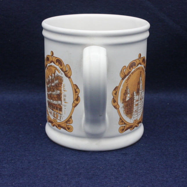 White mug with gold decorative patterns on a blue background