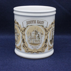 White mug with decorative brown design featuring 'South East' and a building on a blue background