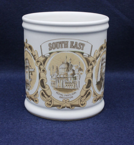 White mug with decorative brown design featuring 'South East' and a building on a blue background