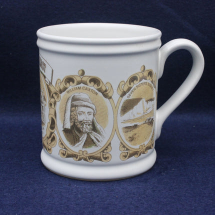 White mug with decorative brown designs featuring a portrait and scenic elements on a blue background