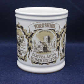 White mug with black and gold Yorkshire-themed design on a blue background