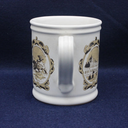 White mug with decorative gold designs on a blue background