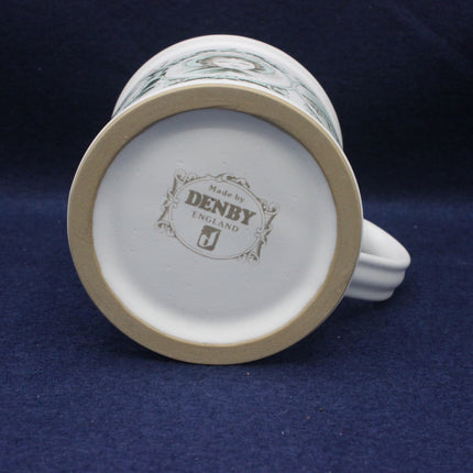 Back view of a ceramic mug with 'Made by Denby England' branding on a blue background