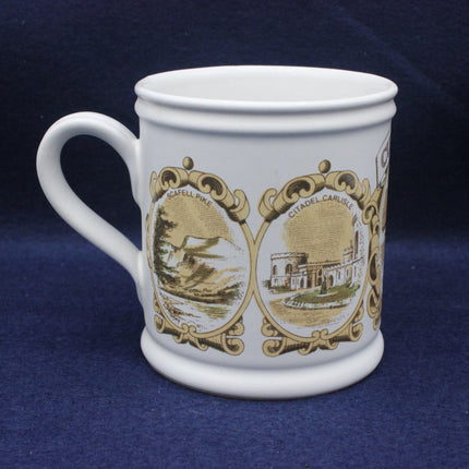 White mug with gold decorative elements and architectural scenes on a blue background