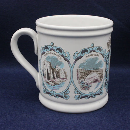 White mug with decorative designs of a castle and bridge on a blue background