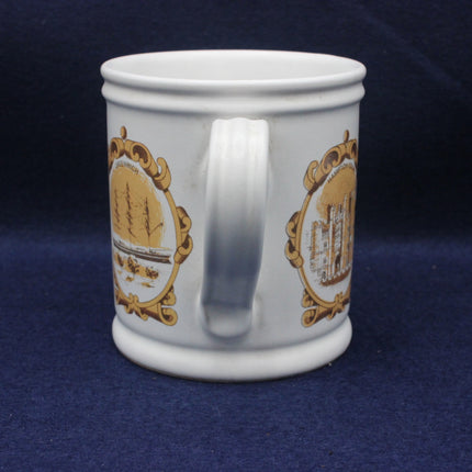 White mug with gold ship design on a blue background